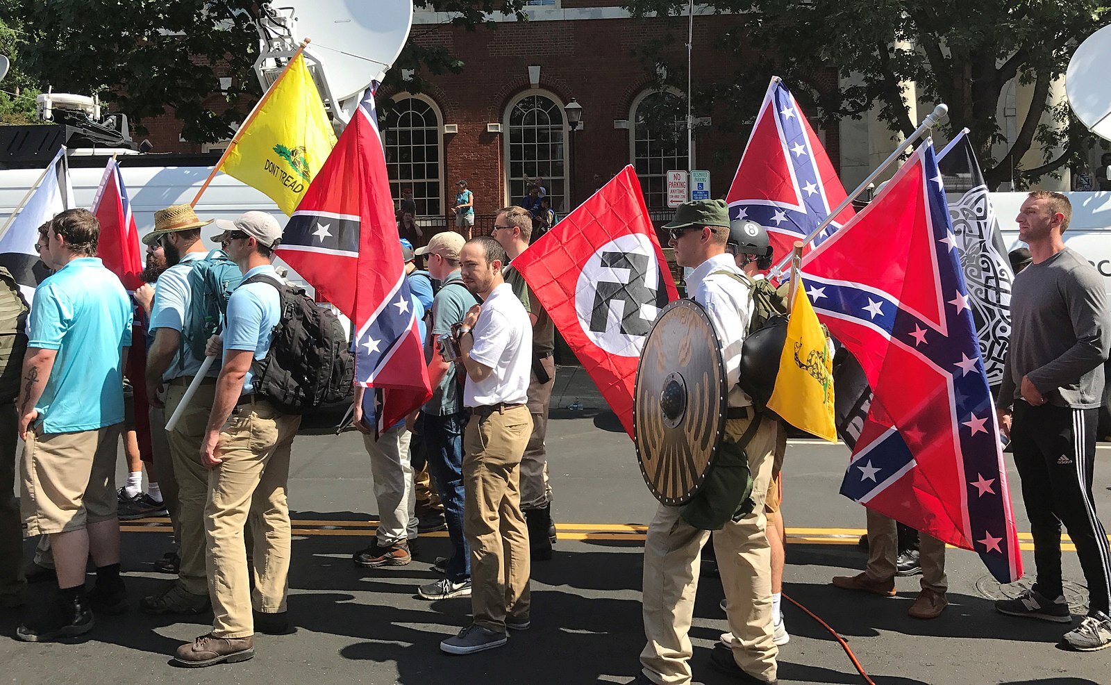 August 12, 2017 – At the “Unite the Right” Rally at Charlottesville, Virginia, alt-right members prepare to enter Emancipation Park holding Nazi, Confederate, and Gadsden "Don't Tread on Me" flags. (Photo by Anthony Crider | Wikimedia Commons)