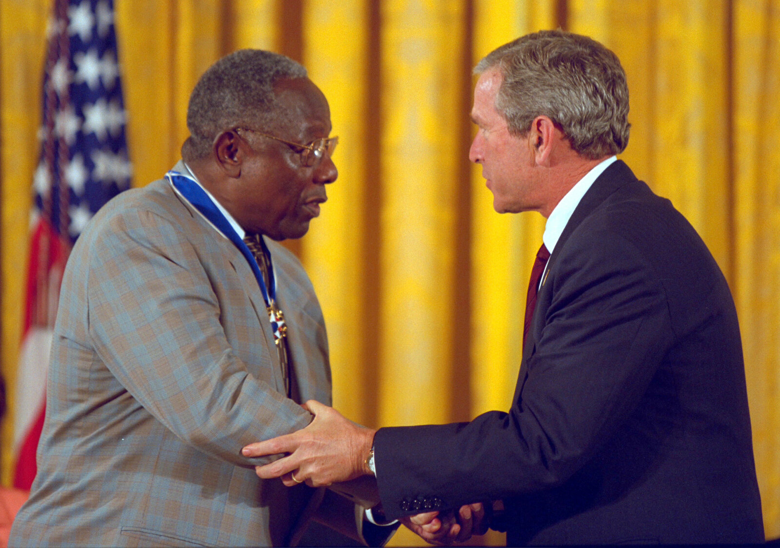 President George W. Bush presents the Presidential Medal of Freedom to baseball legend Hank Aaron, during ceremonies in the East Room. (Photo by the U.S. National Archives)